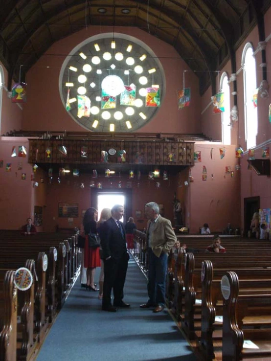 people standing in a church looking at the stained glass window