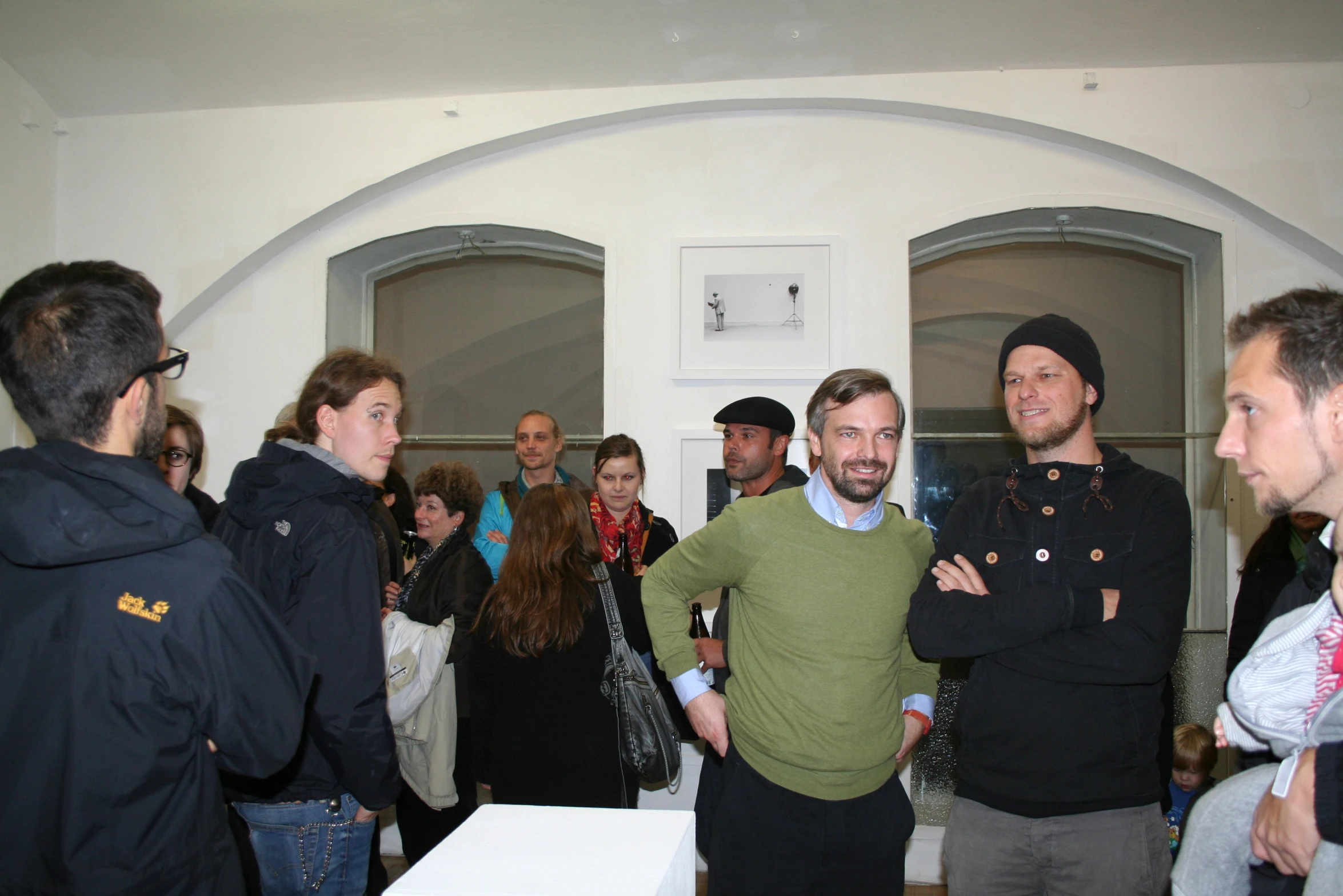 a group of people are talking together and standing in front of a group of men