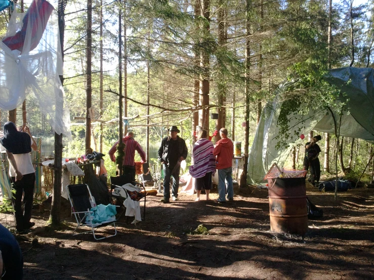 people standing near trees and some tents