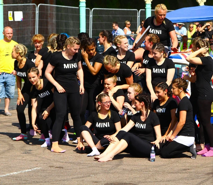 a group of dancers in black are gathered together