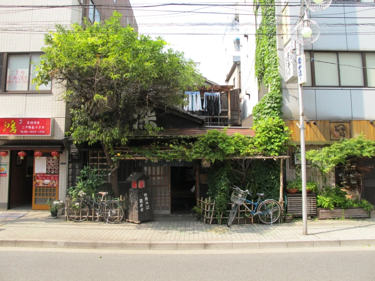 a building covered in plants next to some trees