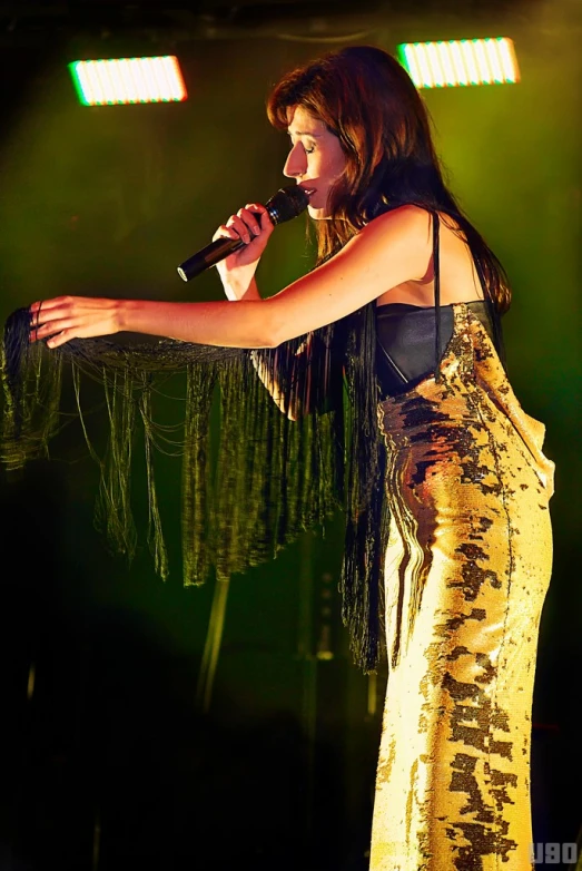 a beautiful young woman in a long dress with a microphone