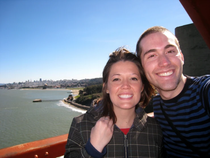 man and woman standing on deck with city view