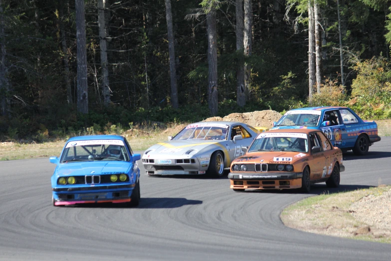 three bmw cars racing on a race track