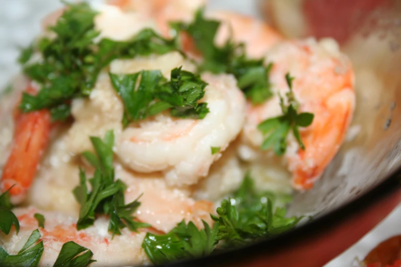 a plate of food that includes shrimp, cheese and parsley