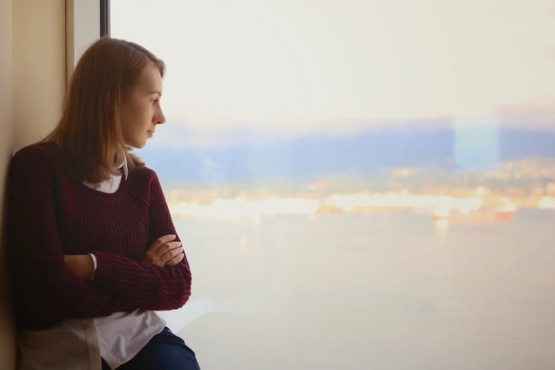 a woman looking out of an open window in her apartment