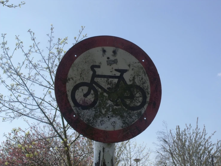 a rusted sign that has some kind of bike on it