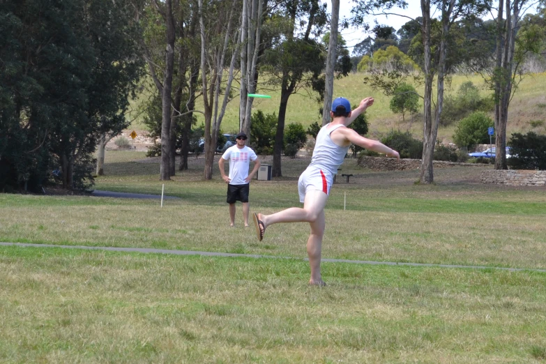 a man with one leg in the air catching a frisbee