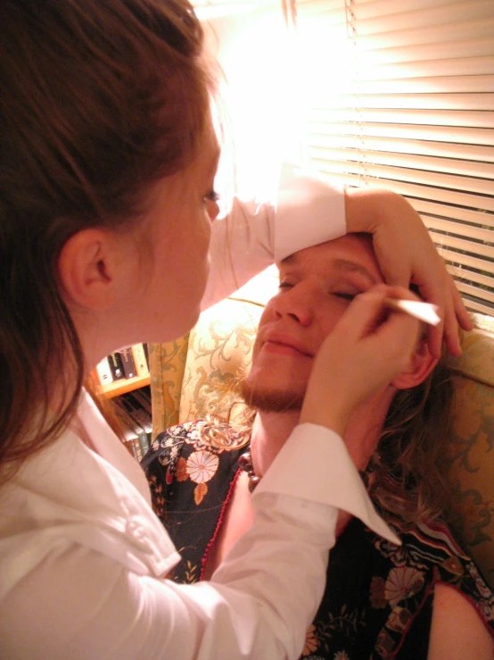 a woman putting on an older man's hat