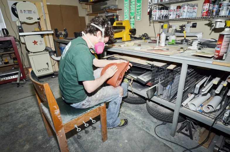 a man who is sewing on some sort of chair