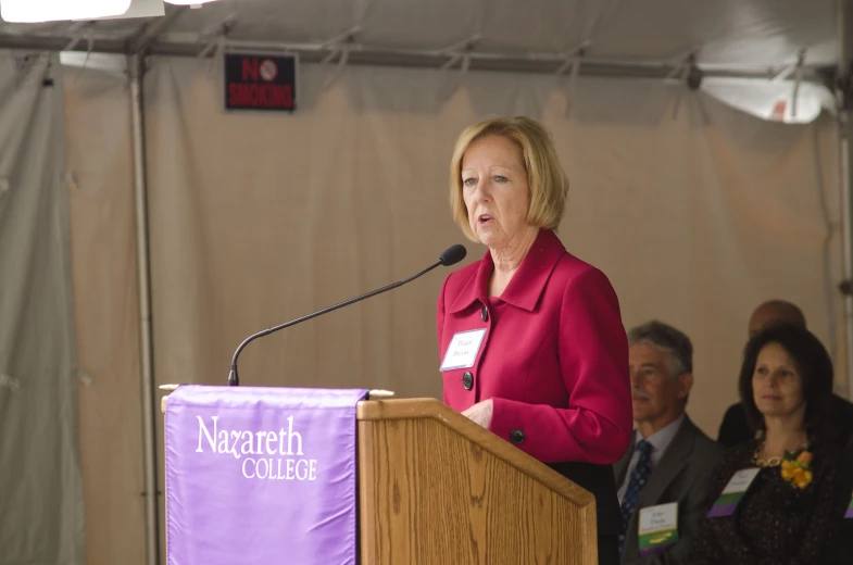 the woman is speaking from the podium at the conference