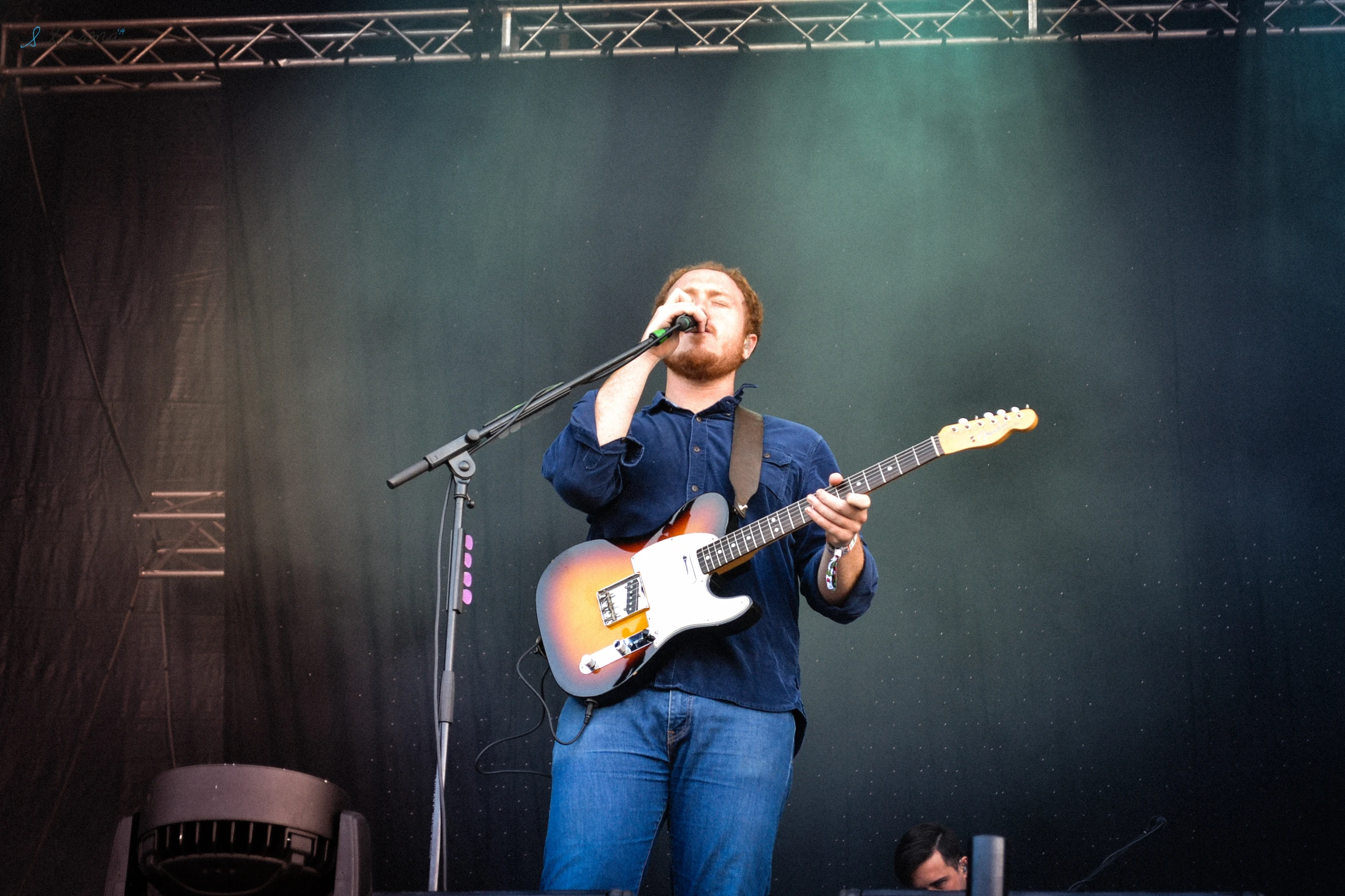 a man with a guitar on stage singing