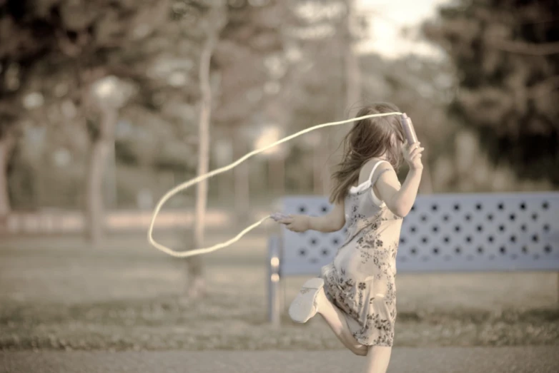 a little girl in a dress that is standing up with a kite