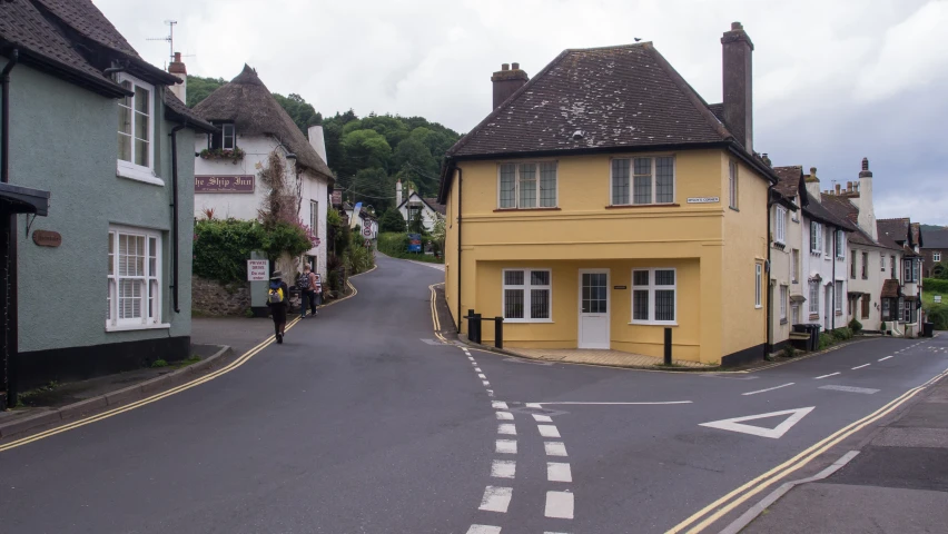 a paved street with houses and a pedestrian