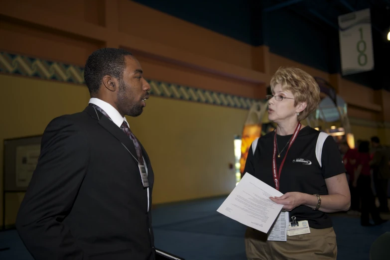 two people in suits talk together while standing