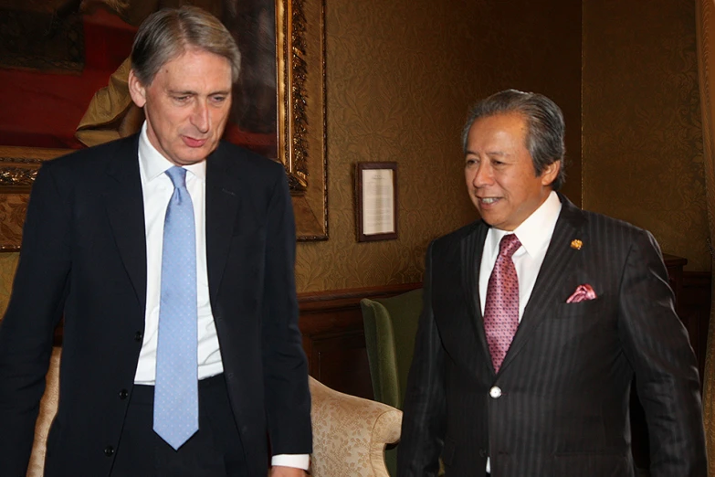 two men wearing suits in front of a mirror