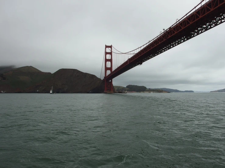 a boat under a suspension bridge on the water