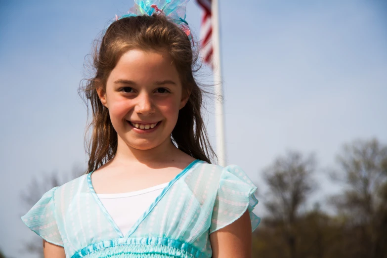 a  is posing with an american flag in the background