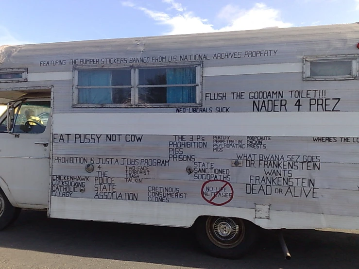 a parked white truck that has a sign attached to it