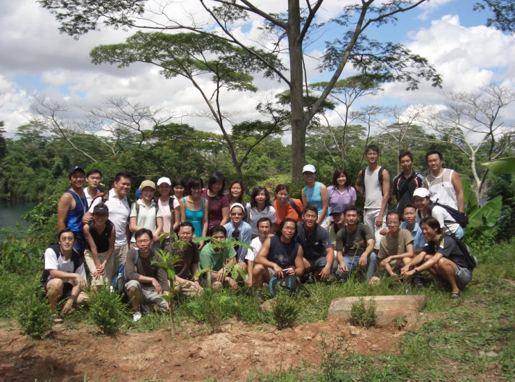 the group is in front of a tree with a few clouds