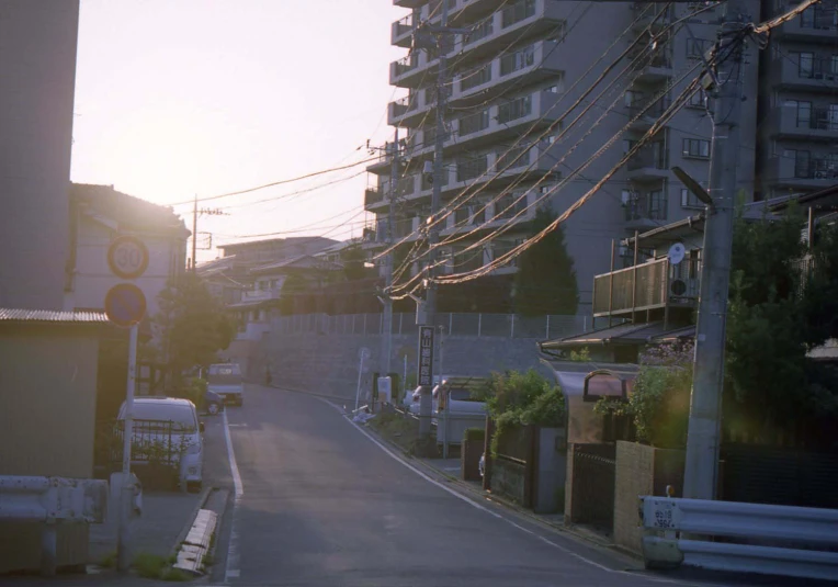 a street with cars and a train on the tracks in front of some buildings