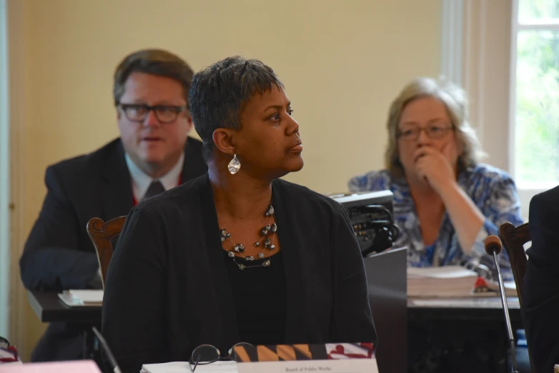 two women are sitting at microphones in front of other people