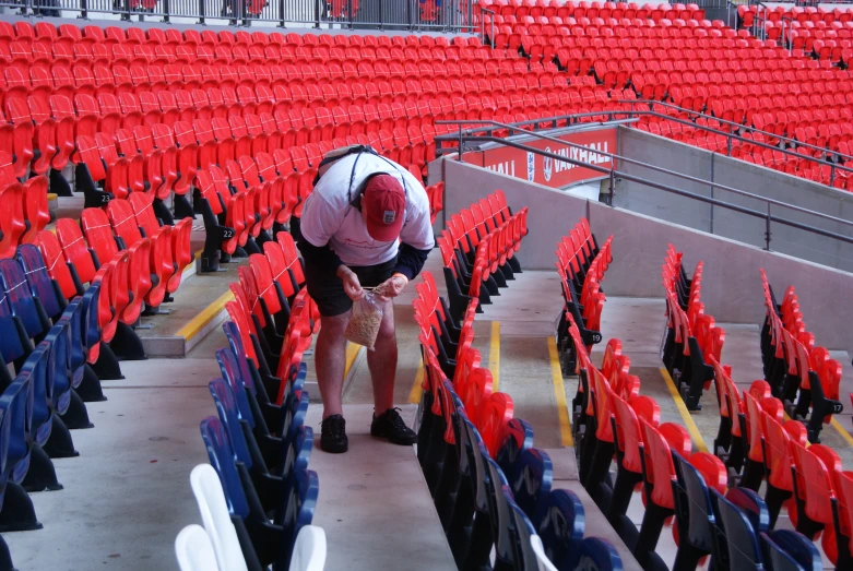 a man is setting up seats in a stadium
