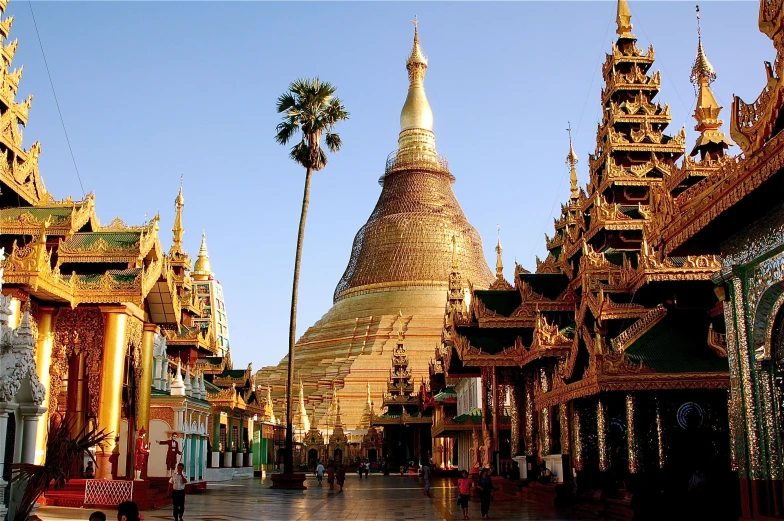 a row of buildings with golden roofs and palm trees