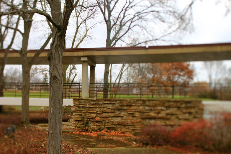 a bridge crossing over water with trees and flowers in the background