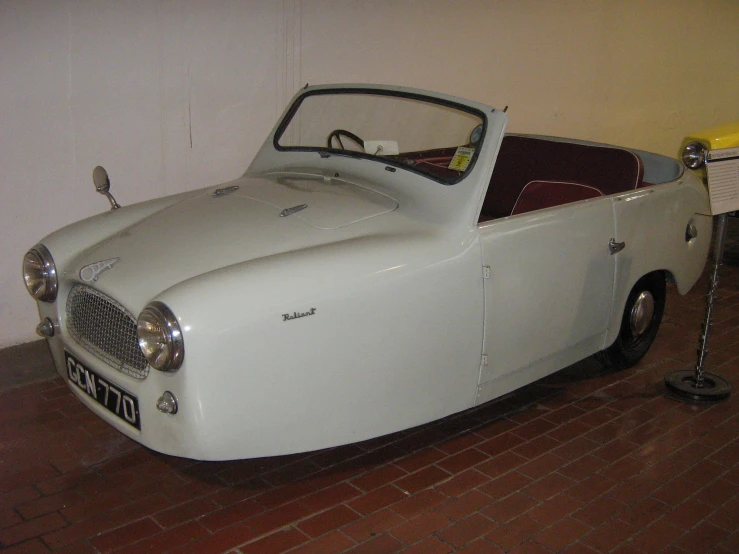 an old car parked inside of a museum