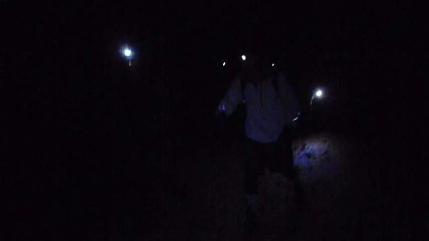 two people standing in the dark looking at soing
