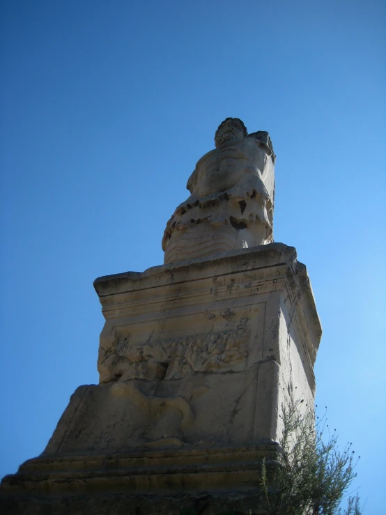 a tall statue near some trees on a sunny day