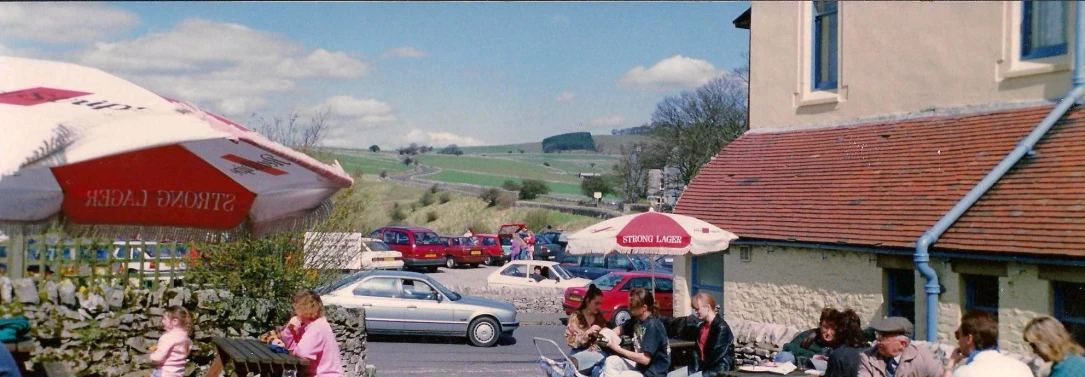 a restaurant in a village with cars going down the road