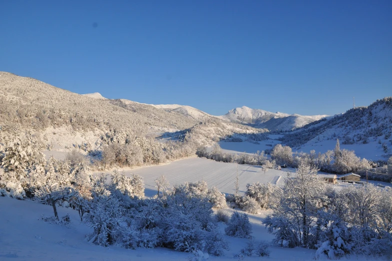 an unpaved road surrounded by snow covered hills