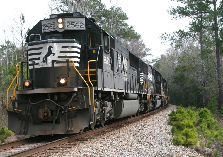 a train coming down the railroad track with some trees