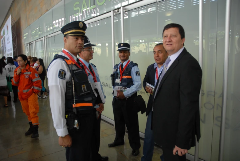 three police officers talking in front of glass wall