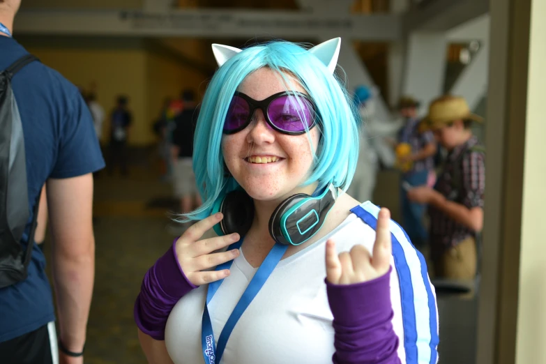 a girl with blue hair, wearing headphones and a blue wig