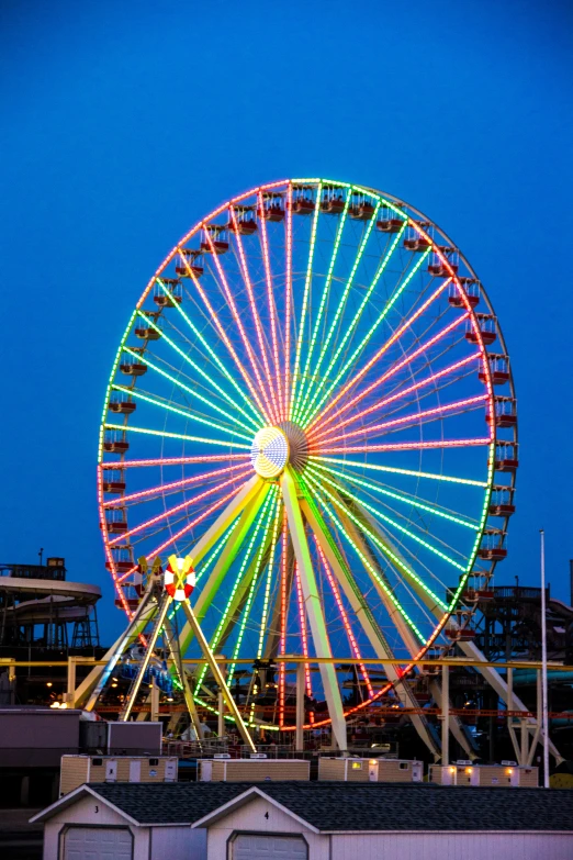 a brightly colored ferris wheel over looking buildings