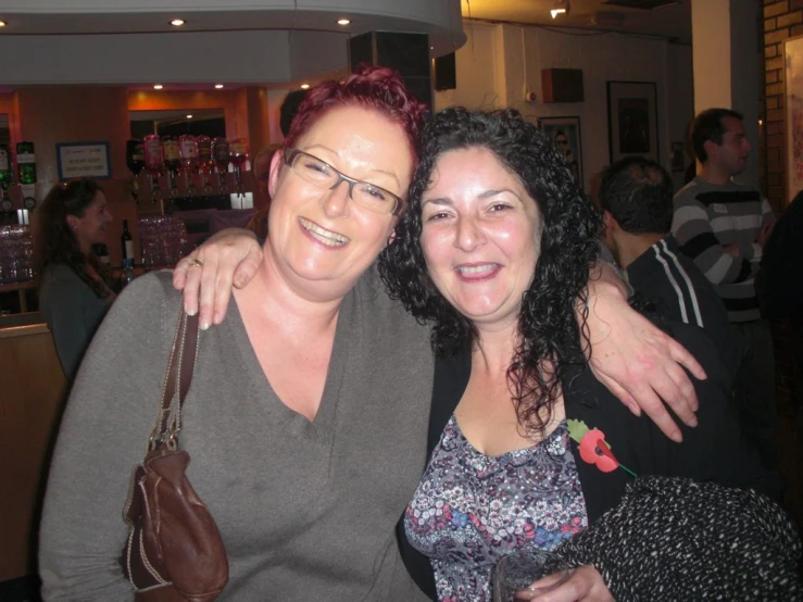 two women standing close together at a wine tasting