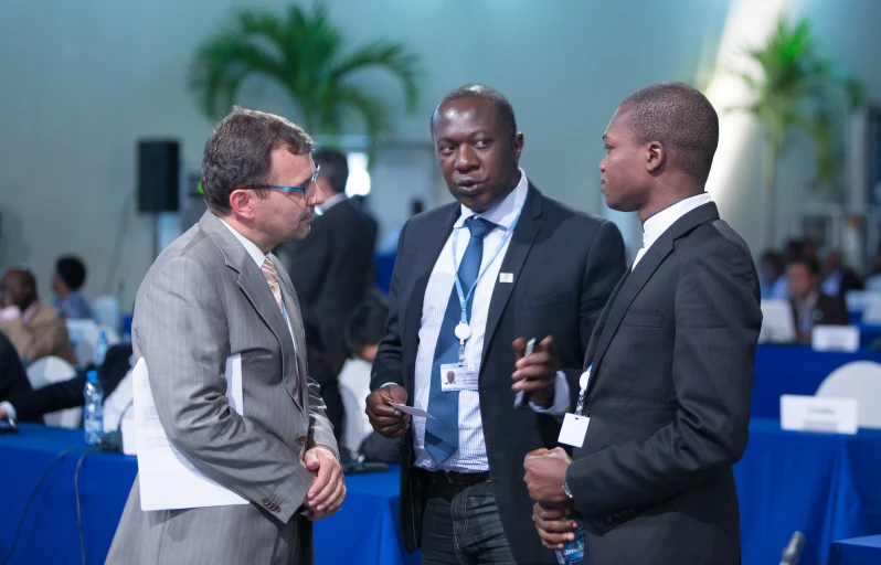 three men standing talking while talking to each other