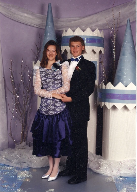 a man and woman wearing formal wear posing for a pograph