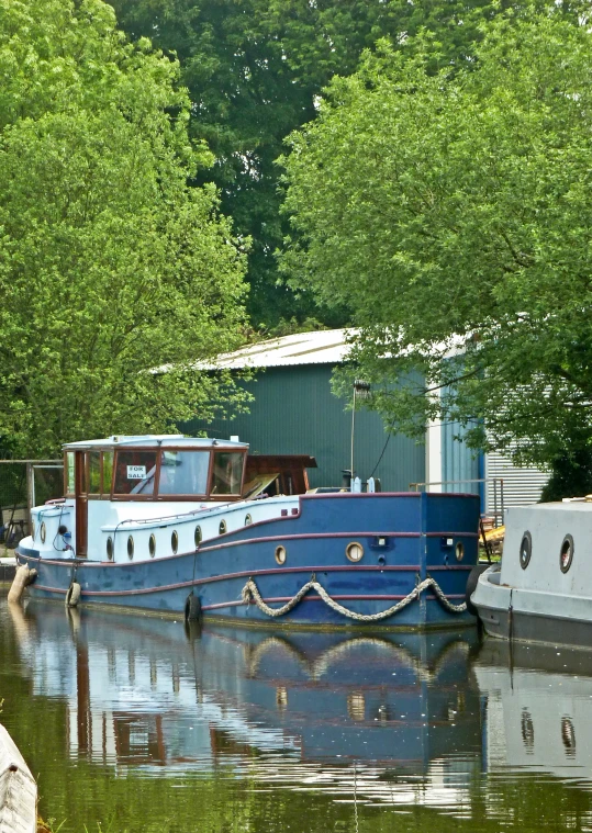 a large blue boat floating on top of a lake