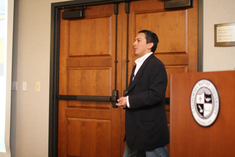 man wearing suit standing in front of a podium