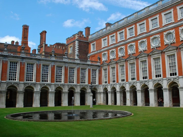 an old, elegant building has fountain in the middle