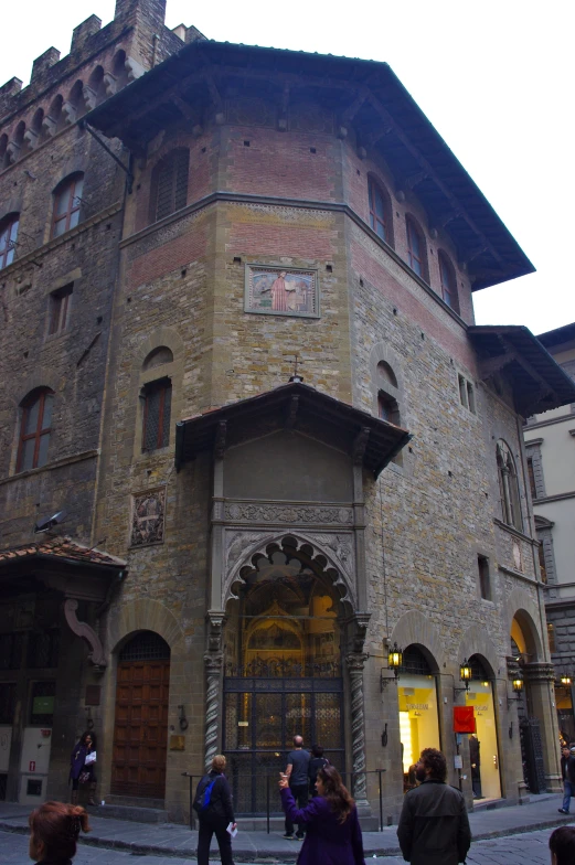 people walking in front of an old building