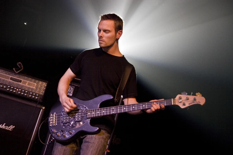 a man with a black shirt plays a bass