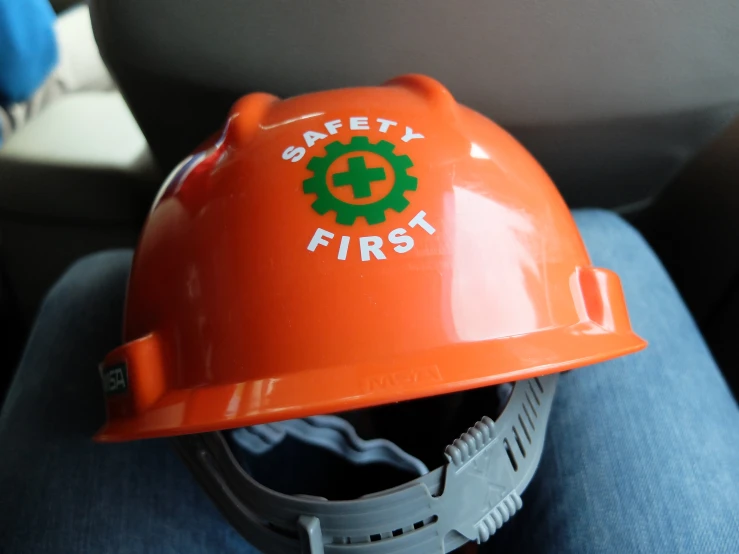 safety first on an orange hardhat while wearing jeans