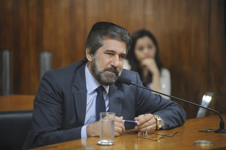 man in business suit talking on telephone at a table