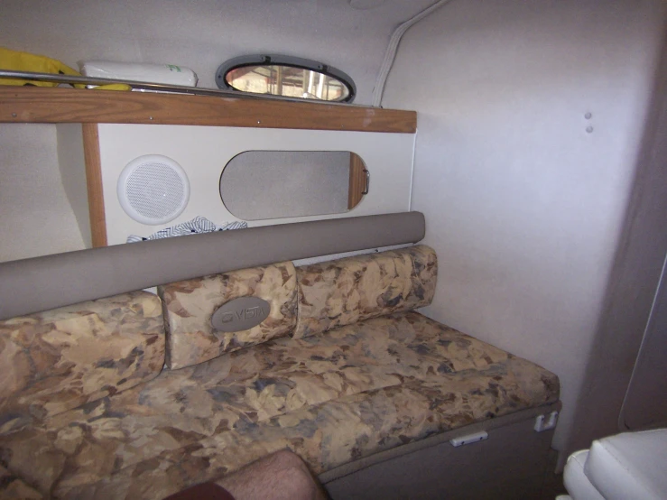 the room inside the mobile home with a couch, mirror and shelf