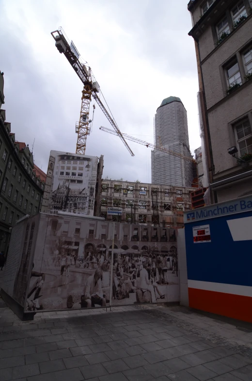 the large cranes are next to tall buildings